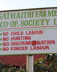 Signboard of Gathaithi Farmers Co-op Society Ltd. with ethical policies in front of a building.